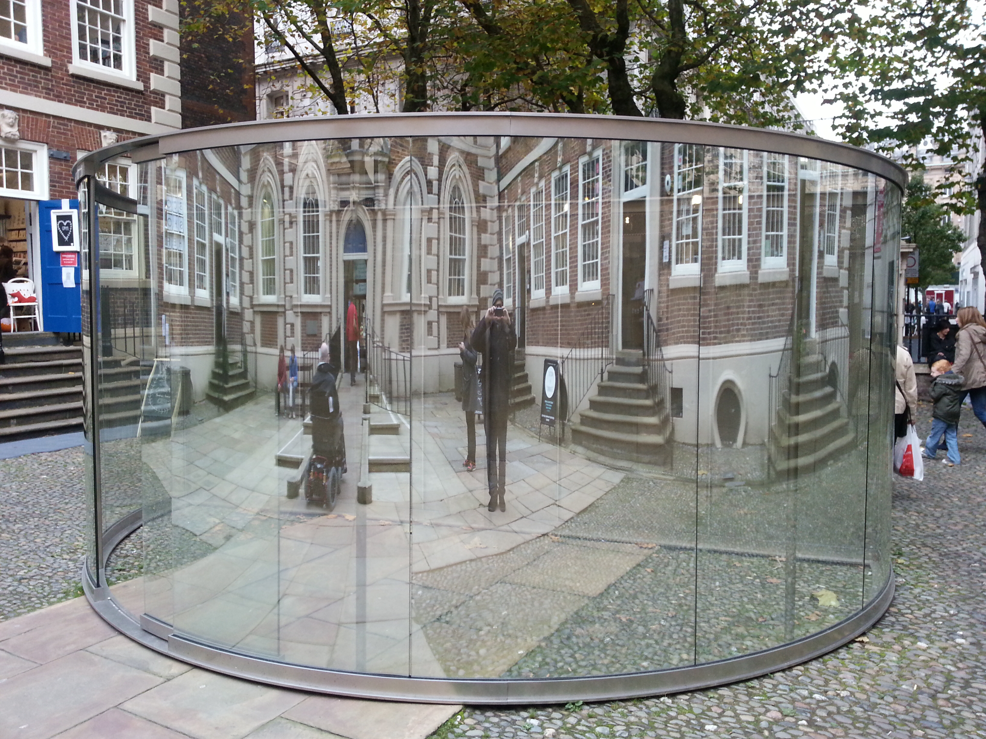 Dan Graham. 2-Way Mirror Cylinder Bisected By Perforated Stainless Steel, 2011-12. Public Pavilion.